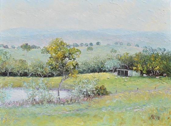 Palette knife oil painting of a country landscape in calming tones of green and gold. There are rolling blue hills, farm shed, grazing sheep, a dam and gum trees.