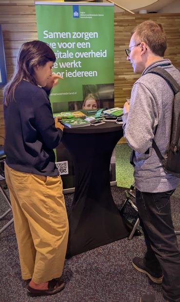Twee personen staand voor een hoge tafel.