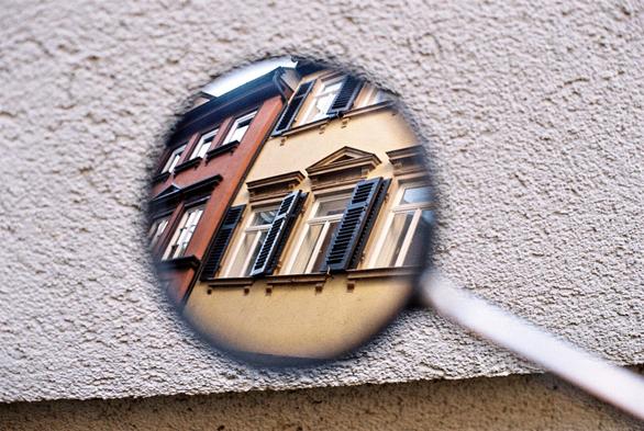 In the center of the picture a round mirror of an older motor scooter visible, showing a row of windows on an old medieval building in the northern oldtown of Esslingen am Neckar.