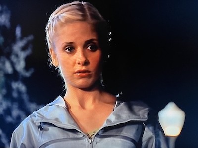 Buffy In what appears to me to be a light blue windbreaker. Also wearing earrings and braided hair. From Buffy The Vampire Slayer Season 4, Episode 1 "The Freshman"