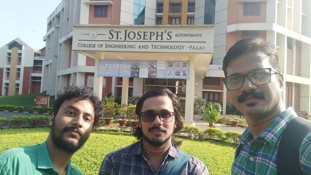 Three people posing for a selfie. In the background is the entrance and signboard for St. Joseph's College of Engineering and Technology. The FOSSDAY banner hangs underneath (you can see our pictures again there if you look carefully)