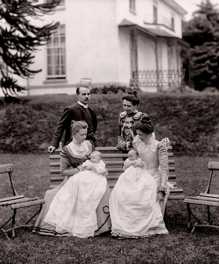 Christening Day. This photo was taken at Sion Lodge, Ferrybank, Waterford. The clergyman pictured had baptised the two babies who are resplendent in their christening robes. One of the women is Mrs Augustus Smith who was a member of the Waterford & South-East of Ireland Archaeological Society. c1895. The National Library of Ireland. No known copyright restrictions.