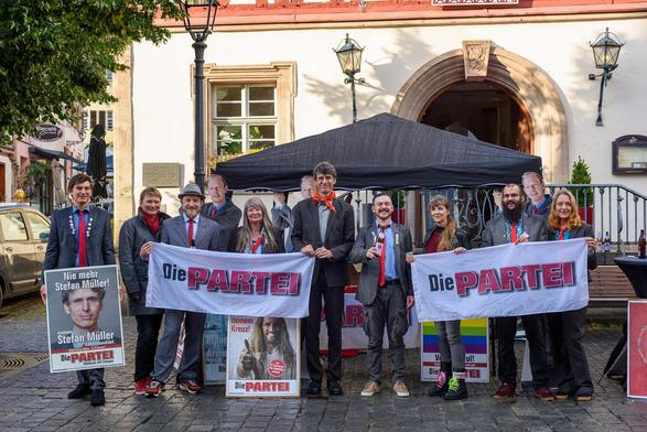 Wahlkampfstand der Partei Die PARTEI mit Kanzlerkandidat Prof. Dr. Stefan Müller, Parteimitgliedern und Parteivorsitzendem Martin Sonneborn als Pappfigur. Herzogenaurach, 27.08.2021