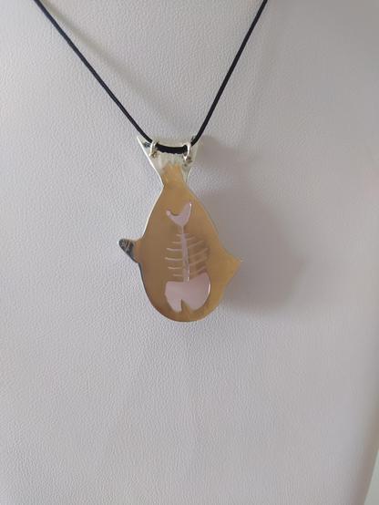 the back side of the fish shaped pendant. it has a herringbone shape cut in the silver