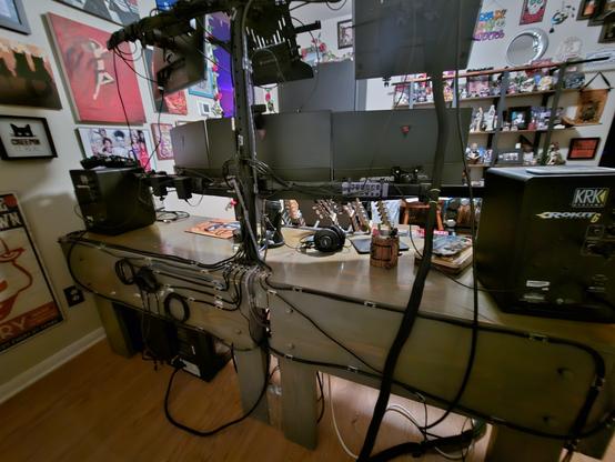 View of a desk from the back with dozens of neatly routed cables