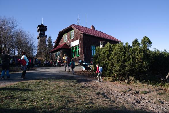Chata a rozhledna na Velkém Javorníku. V popředí mnoho dalších turistů.