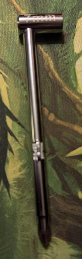 A stainless steel guitar tool with a 90 degree angle socket on one end, and a Phillips head screwdriver on the other.
