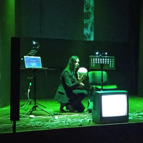 Angela Bonfitto, voce recitante, durante la performance raccoglie una maschera bianca