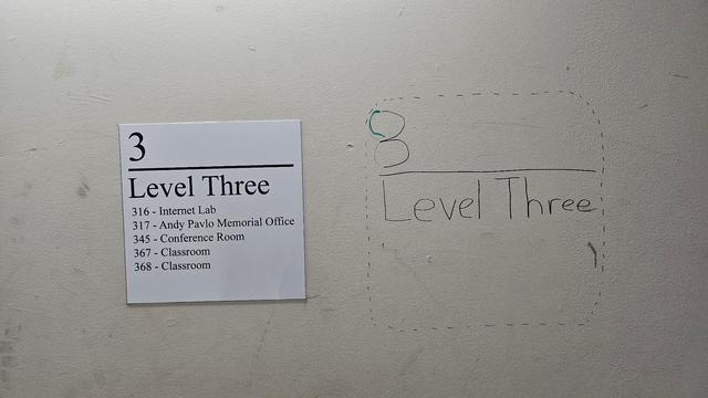 A sign on a wall that reads:

3
Level Three
316 - Internet Lab
317 - Andy Pavlo Memorial Office
345 - Conference Room
367 - Classroom
368 - Classroom