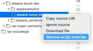 A context menu is open with the option "Remove script override" selected.
The file highlighted is jetpack-boost.js located in a folder structure under app/assets/dist.
Other options in the menu include "Copy source URI," "Ignore source," and "Download file."