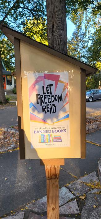 A poster on the side of a Little Free Library that reads: Let Freedom Read 
This Little Free Library shares banned books.