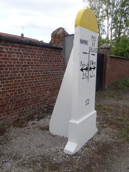 Borne routière indiquant le passage du département de la Somme à celui du Pas-de-Calais, vue de trois-quarts
