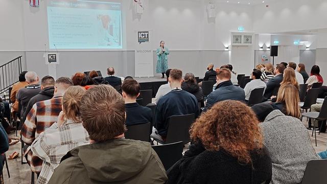 Margaret on stage giving a presentation at the ICT for Education conference. The slide being presented is the current demand for engineers on jobsites.