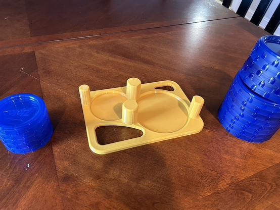A printed tray for lids is as described in the last photo, but now the lids are stacked on the table nearby so the circular indents are exposed.  They're just flat circular spaces slightly bigger than the lids.