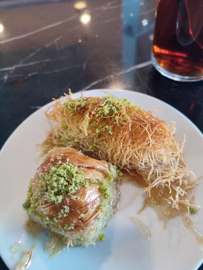 Teller mit baklava, im hintergrund ein glas tee
