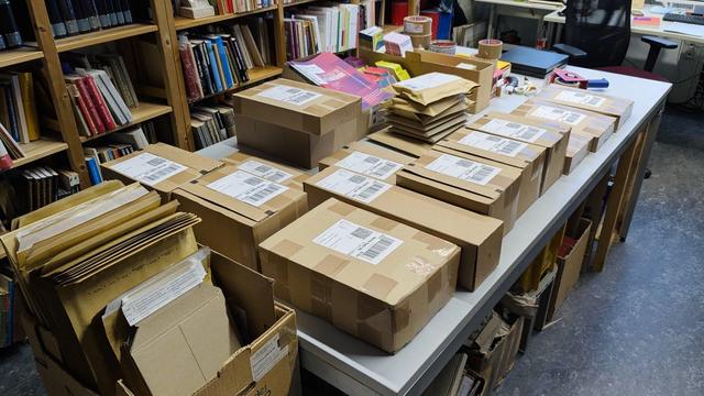 Ein mit vielen fertig gepackten Paketen gefüllter Tisch im Vertrieb bei Dietz Berlin