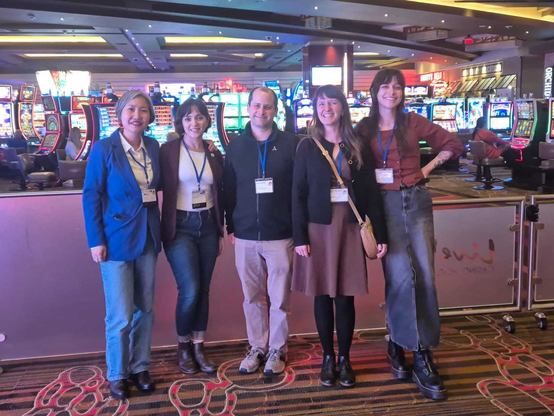 Team FIZ ISE at ISWC 2024 in Baltimore, USA. From left to right: Ann Tan, Mahsa Vafaie, Svcen Hertling, Anna Jacyszyn, and Sarah Rebecca Ondraszek), posing in front of a large room full of slot machines in a casino, where the conference is taking place