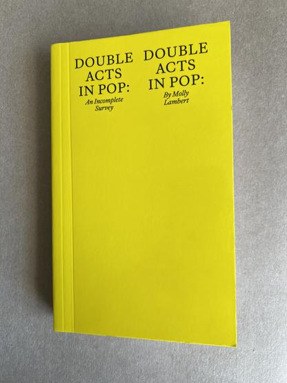 A yellow paperback book: Double Acts in Pop: An Incomplete Survey, by Molly Lambert.