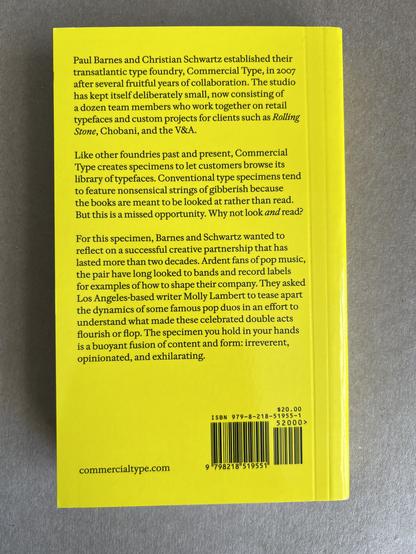 Back cover of Double Acts In Pop: An Incomplete Survey. Black text on a yellow background: “For this specimen, Barnes and Schwartz wanted to reflect on a successful creative partnership that has lasted more than two decades. Ardent fans of pop music, the pair have long looked to bands and record labels for examples of how to shape their company. They asked Los Angeles-based writer Molly Lambert to tease apart the dynamics of some famous pop duos in an effort to understand what made these celebrated double acts flourish or flop. The specimen you hold in your hands is a buoyant fusion of content and form: irreverent, opinionated, and exhilarating.”