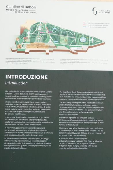 A sign describing the Boboli Gardens. It says, in English:

"The magnificent Boboli Gardens extend behind Palazzo Pitti. Starting in the mid-sixteenth century, the Medici were the first to be involved in the arrangements, creating a garden model that became an example and inspiration for many European courts.

The vast, evenly divided green area is a true outdoor museum filled with ancient, Renaissance, and modern statues, decorated with grottoes - first and foremost the famous one created by Bernardo Buontalenti - the spectacular Neptune and Oceanus fountains as well as many smaller but no less beautiful ones.

Between the eighteenth and nineteenth centuries the Lorraine and Savoia dynasties further enriched the garden expanding its boundaries from the old city walls as far as Porta Romana to the southwest.

The terraced area, where the eighteenth-century Kaffeehaus - a rare example of rococo architecture in Tuscany - and the Lemon House built by Zanobi del Rosso between 1777 and 1778 are located, is particularly fascinating.

A tour of the Boboli Gardens completes and complements your visit to the Pitti Palace to fully grasp the spirit of life at court and to enjoy the experience of a garden that is changing constantly while always and maintaining its traditions."