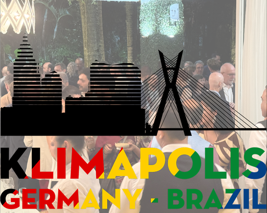 A photo of people gathering at a reception is overlain by the "KLIMAPOLIS" logo