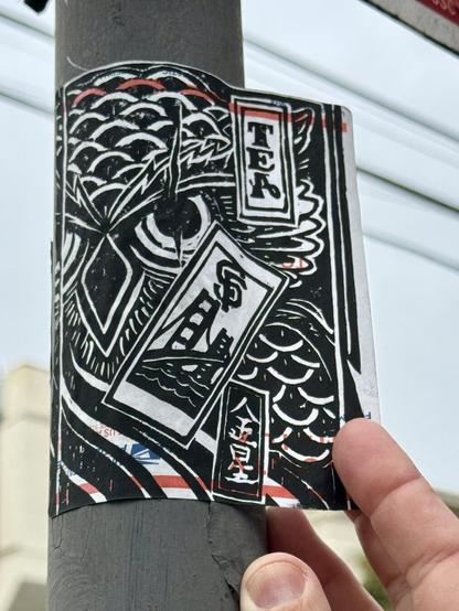 A USPS label that has art printed on it in black ink. The art shows an owl, the San Francisco Golden Gate Bridge, and some other details. It also has the word "TEA" and some kanji on it.