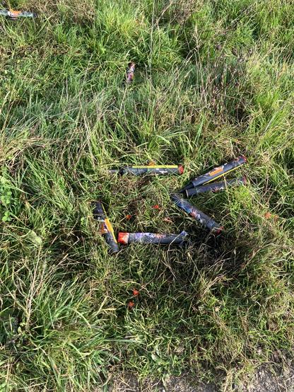 Discarded plastic firework cases on grass