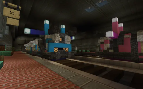 a side angle view of the blue train in the metro tunnel under the station with the pink train also in view

theres a sign denoting this as 1st line