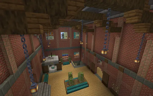 a birds eye view of the waiting and entrence room to the metro tunnels underneath theres an elevator and a set of stairs, theres benches all around an bushes as decorations, theres lanterns hanging from the beams above