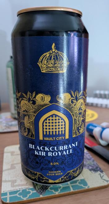 A deep purple can of beer with golden lettering that says Vault City and black currant Kir Royale.  There is a portcullis image on the can.