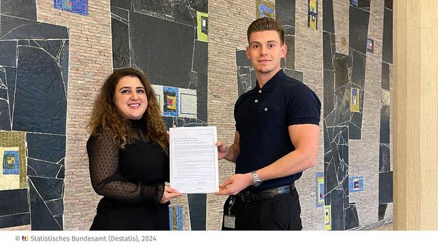 Foto der Urkunde der Charta der Vielfalt, die zwei Beschäftigte des Statistischen Bundesamtes in der Hand halten.