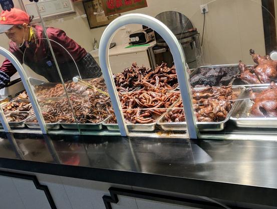A bunch of reddish-colored smoked and preserved meats on a serving counter at a truck stop