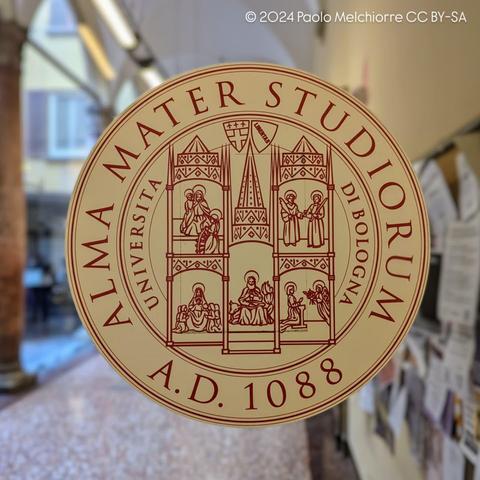 The logo of the University of Bologna on the glass door entrance of the faculty.