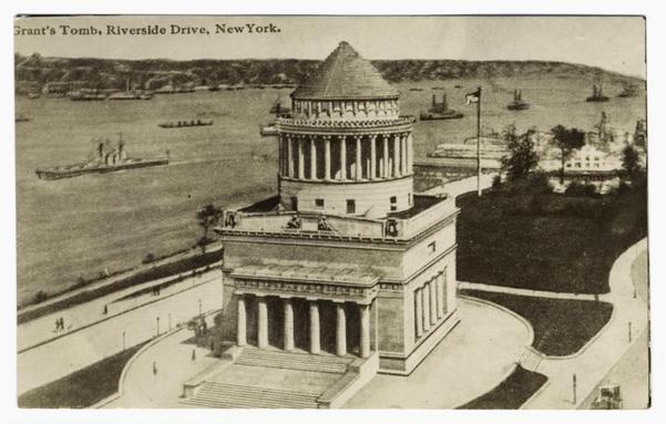 The image is a black and white vintage photograph depicting Grant's Tomb on Riverside Drive in New York. The tomb stands prominently with classical architectural features such as columns at its base leading up to an impressive dome-like structure atop the building. It overlooks a body of water where several ships are visible, suggesting proximity to a harbor or river. There is greenery around the site and pathways that lead towards it from different angles, indicating accessibility for visitors. The photograph's caption reads "Grant’s Tomb, Riverside Drive, New York," identifying both the subject and its location. This image likely dates back to early 20th-century times based on the style of photography and appearance.