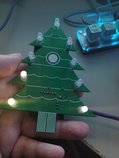 Digistump Holidays Christmas Tree with Oak esp8266 device, front, showing 3 of 9 LEDs lightly glowing orange/yellow
