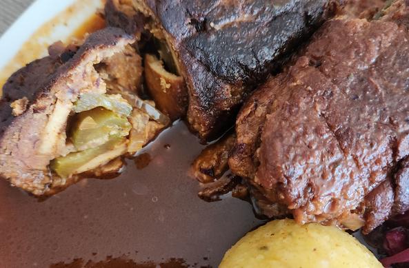Vegane, angeschnittene Roulade in schöner brauner Bratensoße. Dazu Knödel.