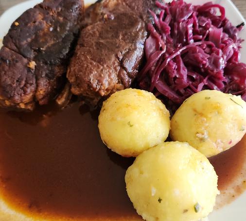 Vegane Roulade in schöner brauner Bratensoße. Dazu Knödel und selbstgemachter Rotkohl.