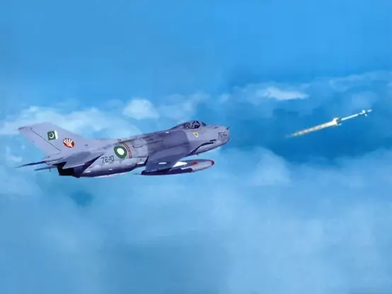 Pakistani F-6 fighter jet flying over clouds while test firing an AIM-9P air-to-air missile.