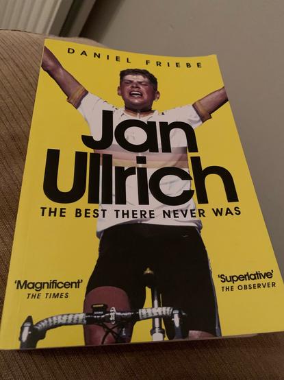 The cover of the book, Jan Ullrich - The Best There Never Was. Against a yellow background, Jan is pictured on a bike, arms outstretched in victory, wearing the German national champion’s jersey. On the cover it also says:

'Magnificent' THE TIMES
'Superlative' THE OBSERVER