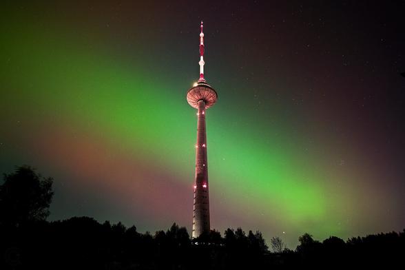 Red and green Northern lights (aurora borealis) of 2024-10-10 behind the Vilnius TV tower in Lithuania