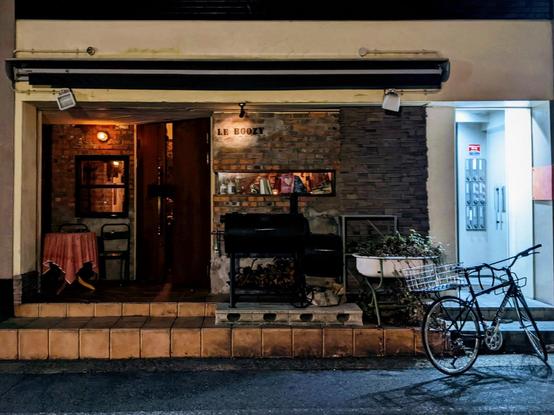 Outside of le boozy with a smoker outside and a parked bicycle
