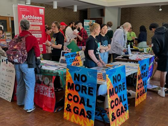 Climate stall inside Fawkner Senior citizens Centre. At the front of the stall are No New Coal and Gas corflutes. Other stalls are in the background including for the local State Labor MP and the Wills Greens candidate