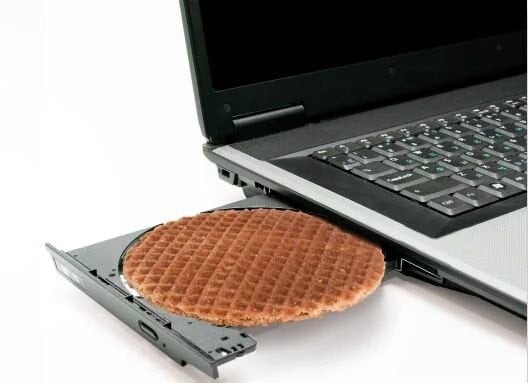 laptop with a cd tray ejected and a stropwafel fitting perfectly in the recessed space