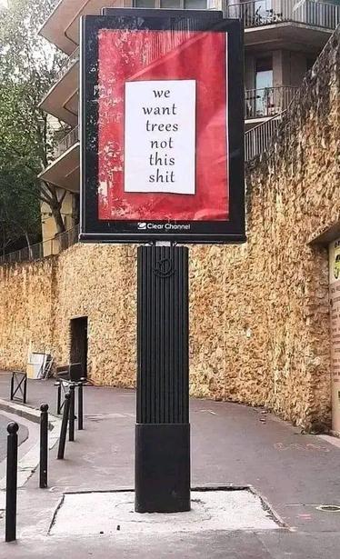 Photo of clearchannel pillar billboard with hacked message "we want trees not this shit"