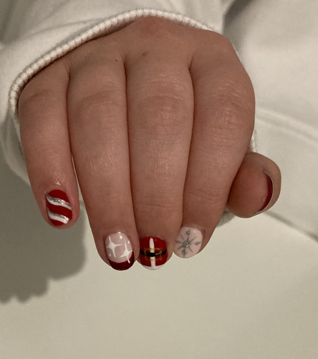Christmas inspired nail art in red, glitter and pink, including candy cane stripes, stars, snowflakes and a Santa tunic and belt