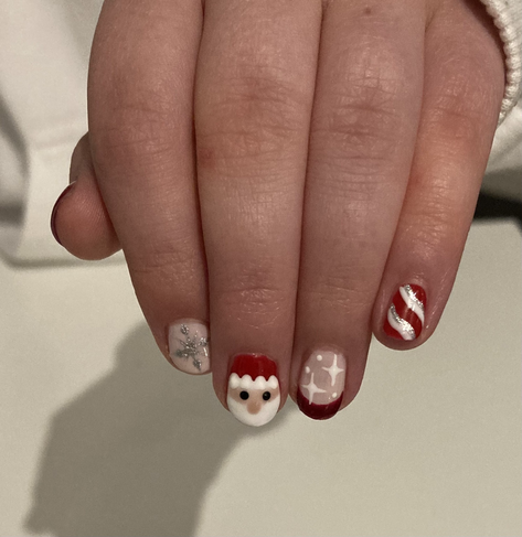 Christmas inspired nail art in red, glitter and pink, including candy cane stripes, stars, snowflakes and a Santa face