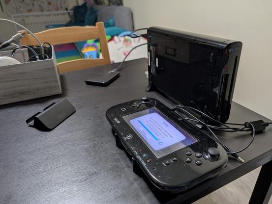A Wii U with its gamepad and a hard drive sitting on a table.