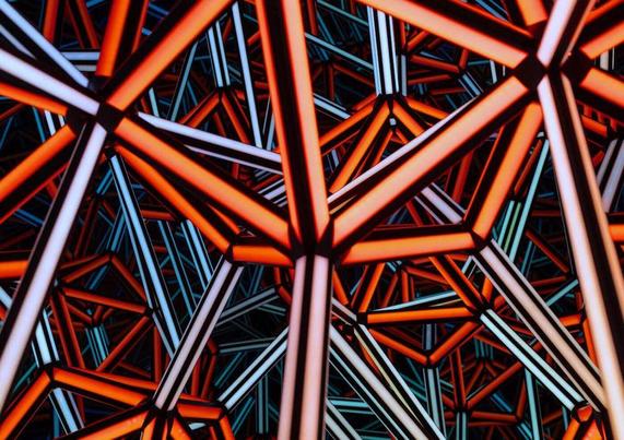 A complex arrangement of interlocking red and white geometric beams forming an abstract pattern.