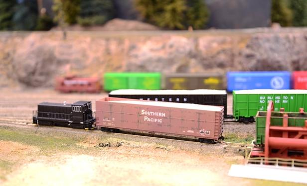 That same tiny black switcher placing a Southern Pacific sawdust car into a rotary dumper.