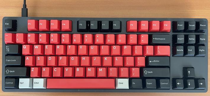 Photo of a Drop ENTR keyboard with black, red, and gray DCX keycaps. The black and red ones are from the Rocky Bird keycap set, while the grey ones are two Command keys (labeled Cmd) surrounding the red space bar, and a single Option key (labeled Opt) between the left control and left Command keys.

The distribution is that of a US standard 87 keys (TenKeyLess, TKL) layout.